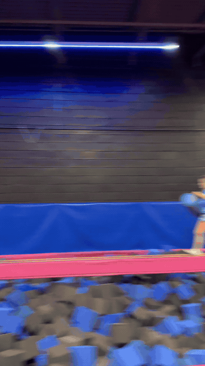 Two jumpers battling on the balance beam over the foam pit